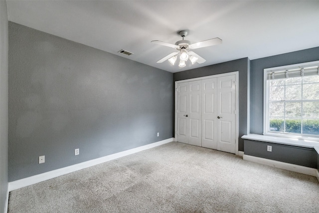 unfurnished bedroom featuring ceiling fan, a closet, and light carpet