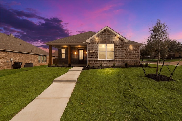 view of front of home featuring a yard and central AC