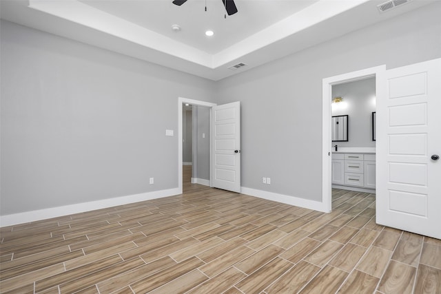 11298 Cedar Dr, Mabank, TX 75156 - unfurnished bedroom featuring light wood-style flooring, baseboards, connected bathroom, a raised ceiling, and ceiling fan
