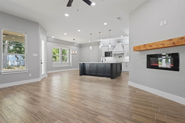 11298 Cedar Dr, Mabank, TX 75156 - unfurnished living room with ceiling fan, a sink, a glass covered fireplace, light wood-style floors, and baseboards