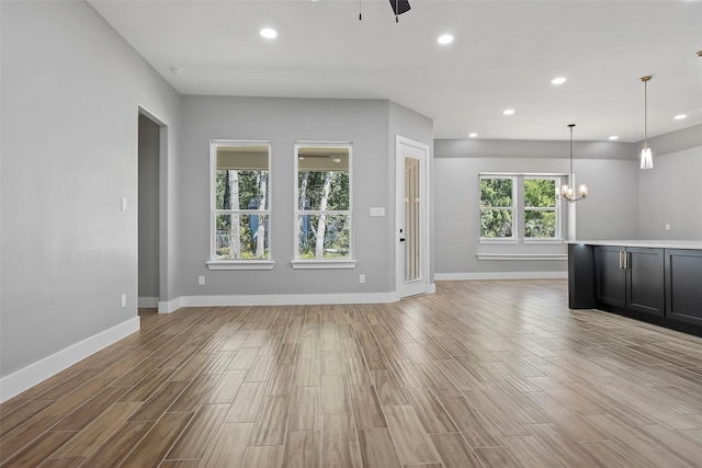 11298 Cedar Dr, Mabank, TX 75156 - unfurnished living room featuring baseboards, a chandelier, recessed lighting, light wood-style flooring, and ceiling fan
