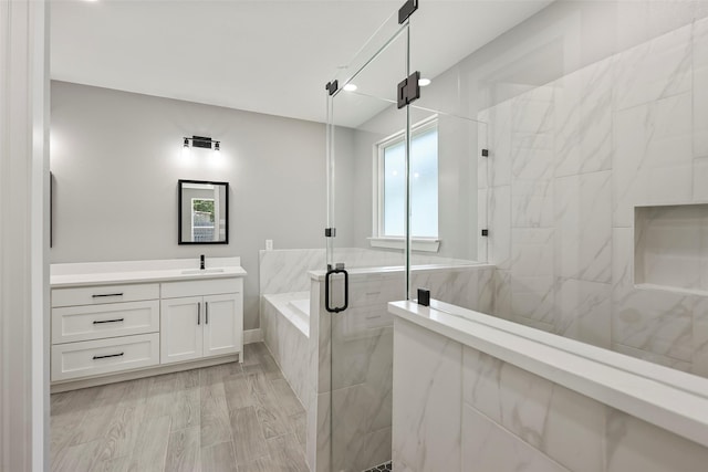 bathroom featuring hardwood / wood-style flooring, vanity, and independent shower and bath