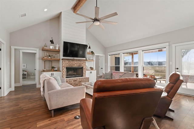 living room with a fireplace, visible vents, a ceiling fan, wood finished floors, and beamed ceiling