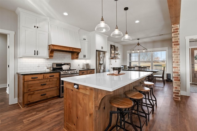 kitchen with stainless steel appliances, a large island, custom exhaust hood, and white cabinets