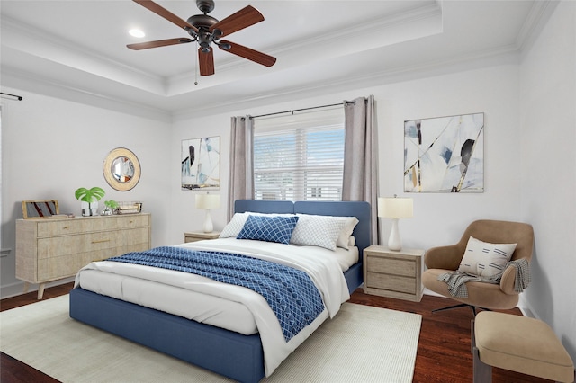 bedroom with a raised ceiling, crown molding, dark wood-style flooring, and ceiling fan