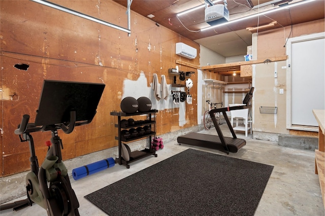 exercise room with a garage and a wall mounted AC