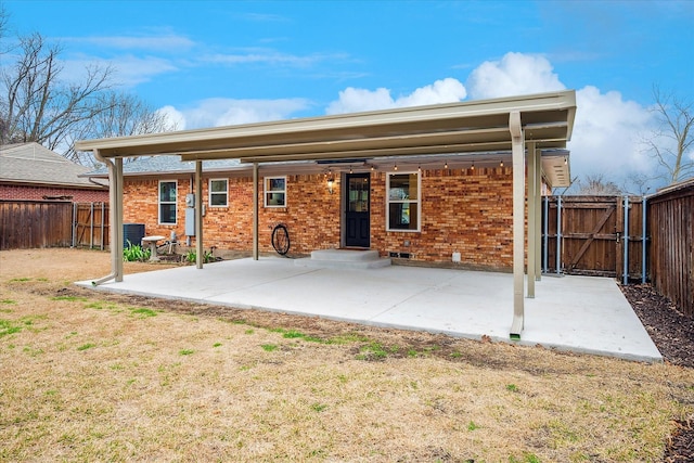 back of house featuring brick siding, a patio area, and fence