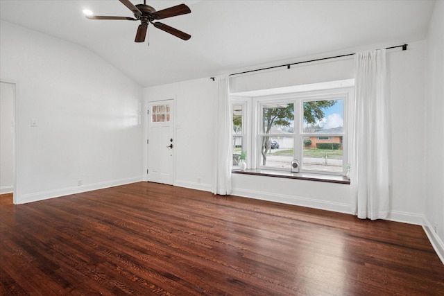 interior space with a ceiling fan, baseboards, vaulted ceiling, and dark wood-type flooring