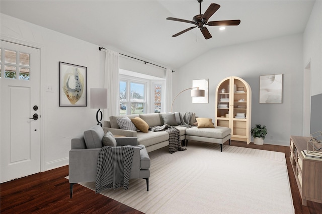 living room with lofted ceiling, dark wood-style floors, ceiling fan, and baseboards