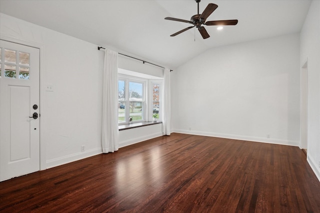 spare room featuring dark wood-style floors, ceiling fan, vaulted ceiling, and baseboards