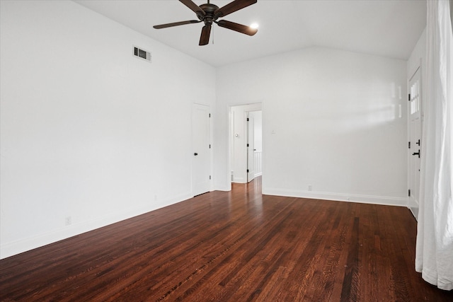 empty room with visible vents, dark wood-type flooring, vaulted ceiling, ceiling fan, and baseboards