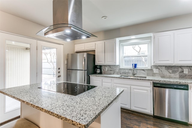 kitchen featuring appliances with stainless steel finishes, island range hood, sink, white cabinets, and a center island