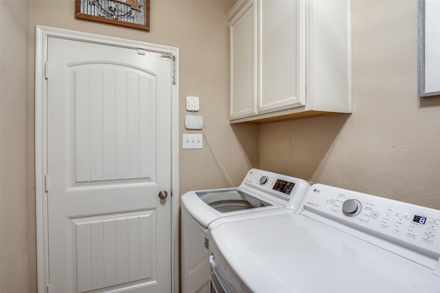 washroom featuring cabinet space and separate washer and dryer