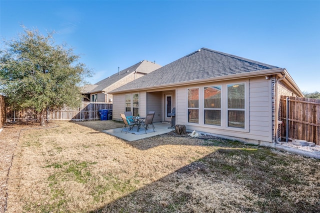 back of property with a yard, a fenced backyard, and a patio