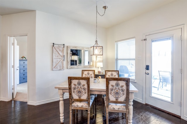 dining area featuring baseboards and dark wood finished floors