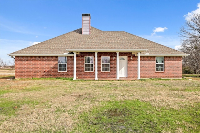 rear view of property featuring a lawn