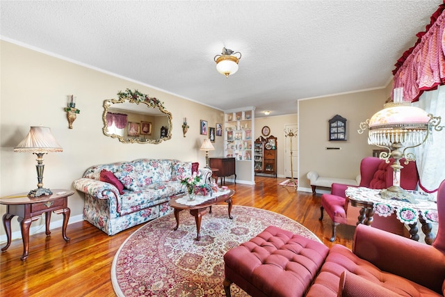 living area with a textured ceiling, baseboards, and wood finished floors