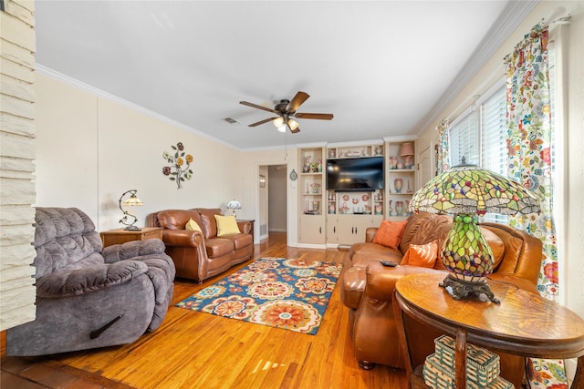 living room with wood finished floors, a ceiling fan, and crown molding