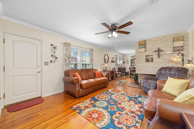 living area featuring baseboards, ceiling fan, ornamental molding, and wood finished floors