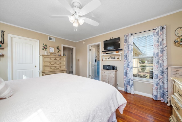 bedroom featuring baseboards, dark wood-type flooring, visible vents, and crown molding