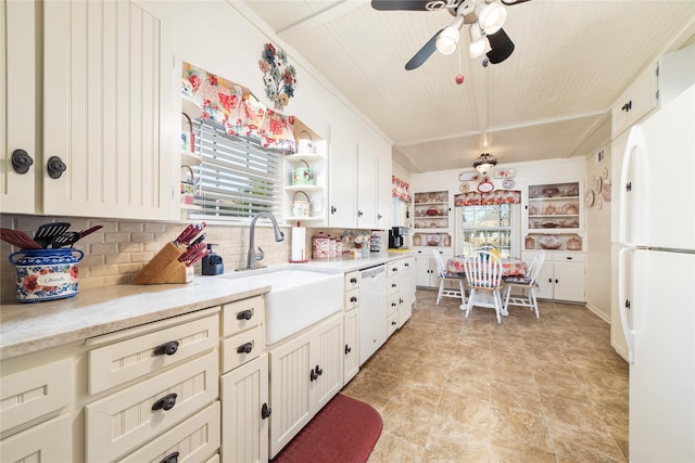 kitchen with decorative backsplash, light countertops, a sink, and freestanding refrigerator