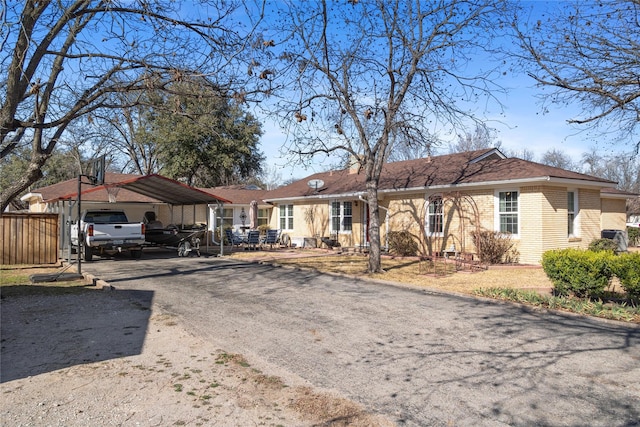 view of parking / parking lot with fence and a detached carport