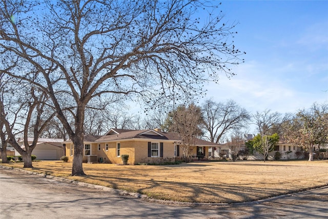 single story home with a garage, a residential view, brick siding, and central air condition unit