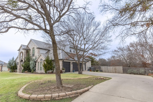 view of front of house with a garage, a front lawn, and central air condition unit