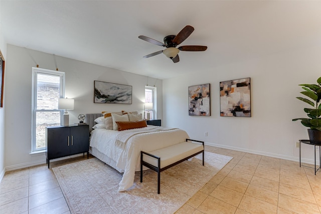 bedroom with ensuite bathroom, light tile patterned floors, and ceiling fan