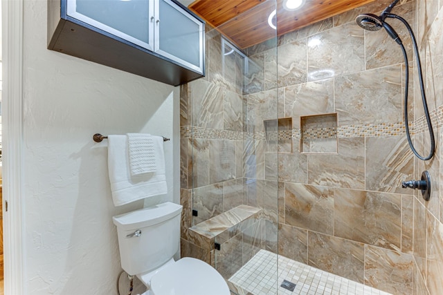 bathroom featuring a shower with shower door and toilet