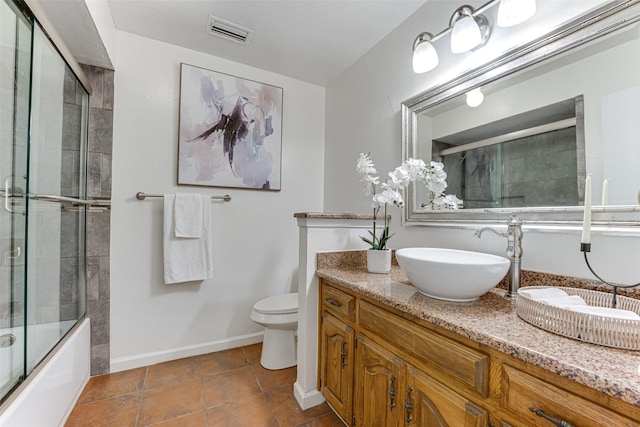 full bathroom featuring vanity, tile patterned floors, enclosed tub / shower combo, and toilet