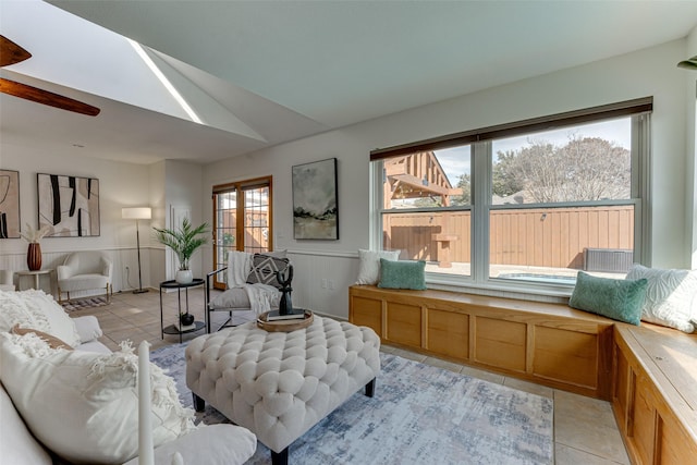 living area with lofted ceiling and light tile patterned floors