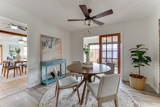 dining room with ceiling fan and light wood-type flooring