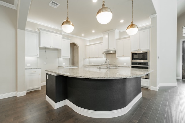 kitchen featuring built in microwave, stainless steel oven, white cabinetry, and hanging light fixtures