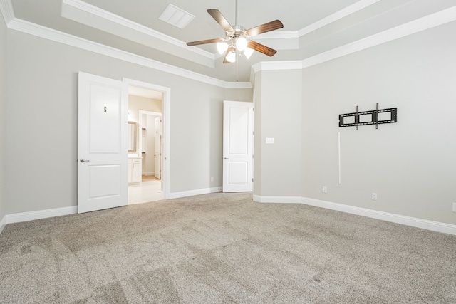 carpeted empty room with ornamental molding, a raised ceiling, and ceiling fan