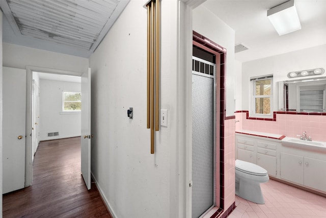 hallway with sink and tile walls