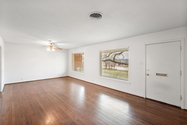 empty room featuring dark wood-type flooring and ceiling fan