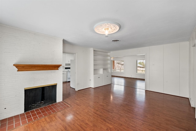 unfurnished living room with built in features, a fireplace, and dark hardwood / wood-style flooring