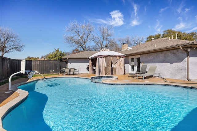 view of pool featuring an in ground hot tub, a patio area, and a gazebo