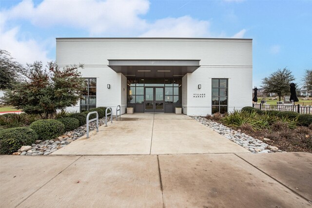 view of property with a carport, concrete driveway, and fence