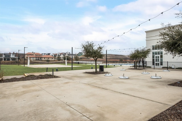 view of community with a yard, volleyball court, a residential view, and fence