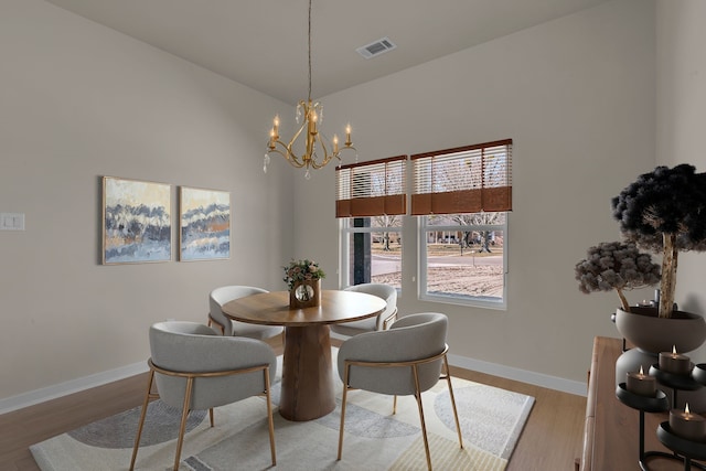 dining room with a notable chandelier and light wood-type flooring