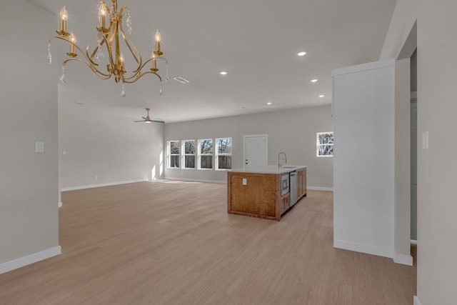 kitchen with ceiling fan, sink, light hardwood / wood-style floors, and hanging light fixtures