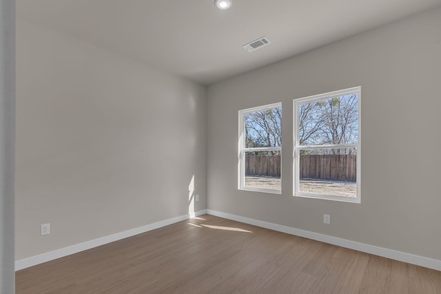 unfurnished room with hardwood / wood-style flooring