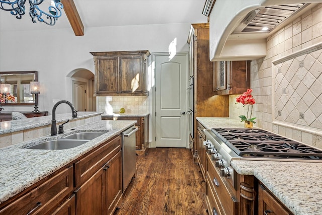 kitchen with arched walkways, a sink, appliances with stainless steel finishes, ventilation hood, and dark wood finished floors