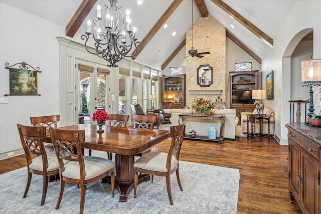 dining area featuring arched walkways, wood finished floors, high vaulted ceiling, beam ceiling, and ceiling fan with notable chandelier