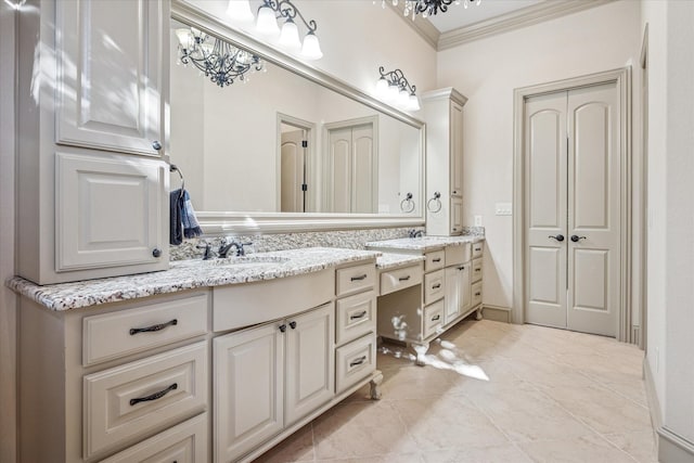 bathroom with ornamental molding, a chandelier, and vanity