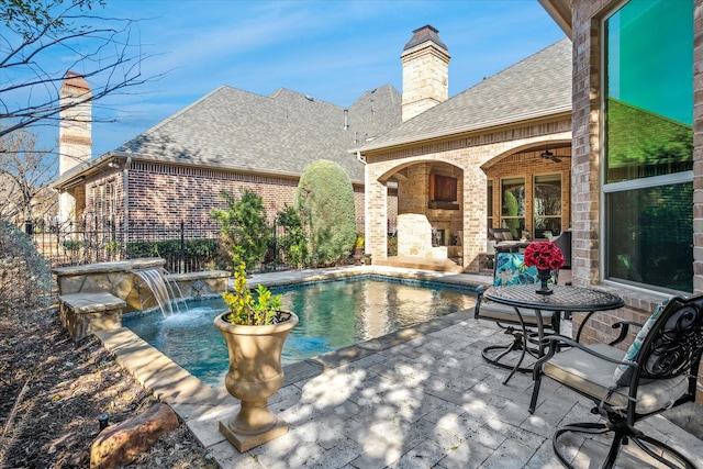 outdoor pool featuring a patio area, a fireplace, fence, and ceiling fan