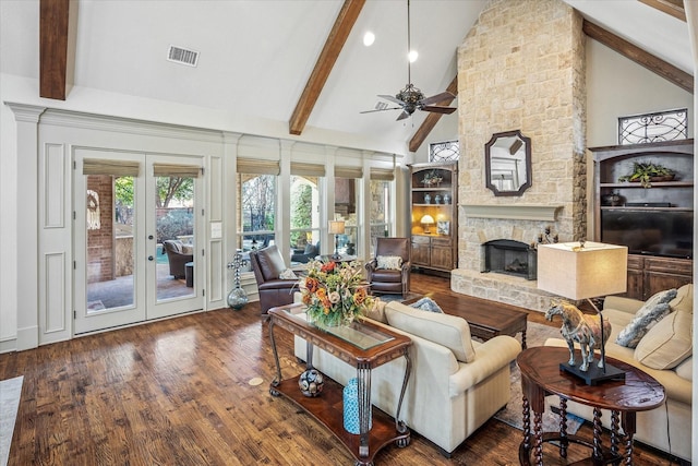 living room featuring french doors, visible vents, a stone fireplace, wood finished floors, and beamed ceiling