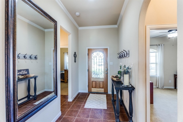 tiled foyer entrance with crown molding and ceiling fan